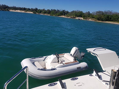 rear of Black Diamond with tender on the water