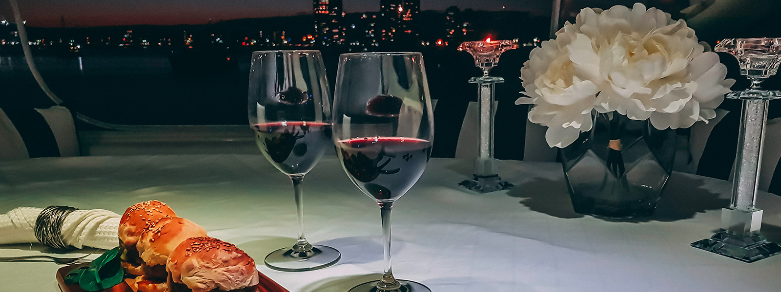 Yacht table setting with flowers wine and sliders at night